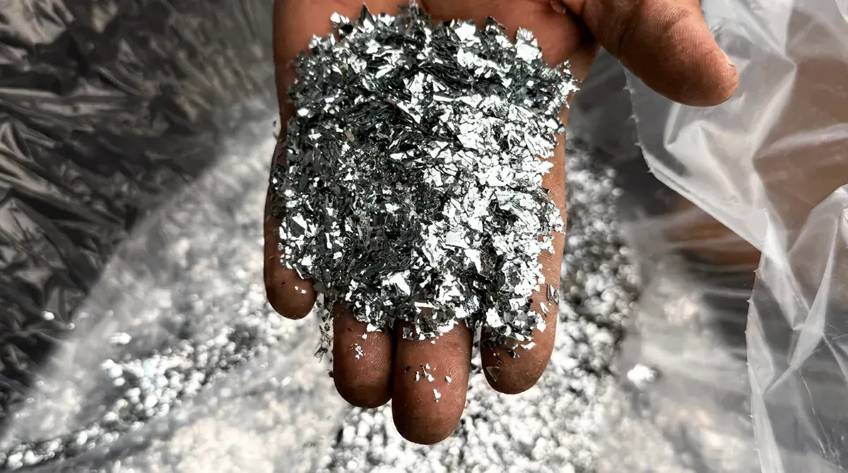 Hand holding silver flake chips before broadcasting